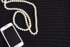 Шарики и телефон ` s женщин на черноте связали ткань стоковое изображение Шарики и телефон ` s женщин на черноте связали ткань стоковое изображение