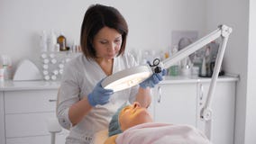 Шкаф средн-постаретый женщиной лежа с косметической лампой Шкаф средн-постаретый женщиной лежа с косметической лампой