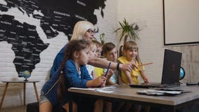 Школьный учитель и группа в составе элементарные студенты работая с компьтер-книжкой и после этого принимая selfie совместно Учит сток-видео Школьный учитель и группа в составе элементарные студенты работая с компьтер-книжкой и после этого принимая selfie совместно Учит сток-видео