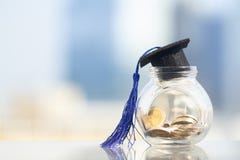 Шляпа градации с голубым tassel поверх стеклянных опарника или копилки стоковое фото rf Шляпа градации с голубым tassel поверх стеклянных опарника или копилки стоковое фото rf