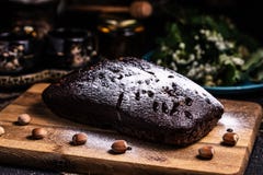 Шоколадный торт на деревянной доске с фундуками Напудренная замороженность Пирожное шоколада стоковое изображение rf Шоколадный торт на деревянной доске с фундуками Напудренная замороженность Пирожное шоколада стоковое изображение rf