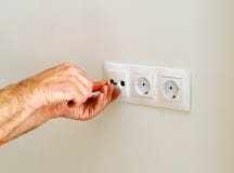 Электрик устанавливая электророзетки в дом стоковое фото rf Электрик устанавливая электророзетки в дом стоковое фото rf