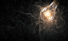Электрическая лампочка на каменной поверхности Стоковые Изображения Электрическая лампочка на каменной поверхности Стоковые Изображения
