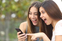 Эйфоричные друзья наблюдая видео на smartphone стоковые изображения rf Эйфоричные друзья наблюдая видео на smartphone стоковые изображения rf