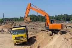 Экскаватор на строительной площадке нагрузит тележку с песком стоковое фото Экскаватор на строительной площадке нагрузит тележку с песком стоковое фото