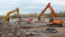 Экскаваторы разбирая большую старую промышленную зону для повторной разработки в будущем торговом районе стоковое изображение rf Экскаваторы разбирая большую старую промышленную зону для повторной разработки в будущем торговом районе стоковое изображение rf