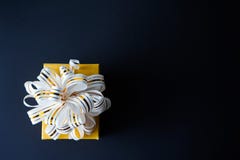 Элегантная подарочная коробка в оболочке в белом и золоте striped лента на черной текстурированной предпосылке r День отца, день стоковая фотография rf Элегантная подарочная коробка в оболочке в белом и золоте striped лента на черной текстурированной предпосылке r День отца, день стоковая фотография rf