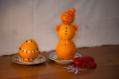 Элегантный снеговик от tangerines в красной крышке от морковей в поддоннике и красной жабе от болгарского перца на деревянном сто стоковые изображения Элегантный снеговик от tangerines в красной крышке от морковей в поддоннике и красной жабе от болгарского перца на деревянном сто стоковые изображения
