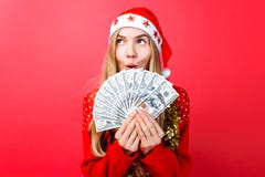 Эмоциональная девушка в красных свитере и шляпе Санта Клауса, в восхищении держа деньги на красной предпосылке стоковое фото Эмоциональная девушка в красных свитере и шляпе Санта Клауса, в восхищении держа деньги на красной предпосылке стоковое фото
