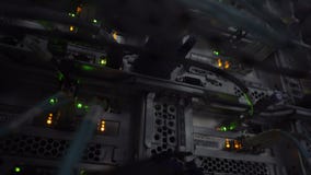 Эпицентр деятельности сетевого подключения локальных сетей Моргать освещает в темной комнате сервера, взгляде конца-вверх кабелей Эпицентр деятельности сетевого подключения локальных сетей Моргать освещает в темной комнате сервера, взгляде конца-вверх кабелей