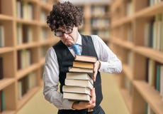 Юмористический профессор болвана с много книг в библиотеке стоковые изображения rf Юмористический профессор болвана с много книг в библиотеке стоковые изображения rf