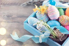 Яичка пасхи красочные покрашенные с цветками весны и голубая лента сатинировки на древесине Стоковое Фото Яичка пасхи красочные покрашенные с цветками весны и голубая лента сатинировки на древесине Стоковое Фото