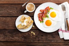 Яичницы, бекон и итальянский хлеб ciabatta на белой плите Чашка кофе Взгляд сверху завтрака Деревянная предпосылка Стоковая Фотография RF Яичницы, бекон и итальянский хлеб ciabatta на белой плите Чашка кофе Взгляд сверху завтрака Деревянная предпосылка Стоковая Фотография RF