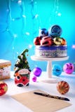 Яркий карлик игрушки с жизнерадостной стороной и колокол на сияющей крышке шариков, коробке бумажной ручки письма на белой предпо стоковое фото rf Яркий карлик игрушки с жизнерадостной стороной и колокол на сияющей крышке шариков, коробке бумажной ручки письма на белой предпо стоковое фото rf