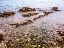Ясное море покрывая красочные утесы стоковые изображения Ясное море покрывая красочные утесы стоковые изображения