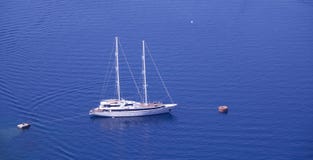 Яхта поставленная на якорь для того чтобы подпирать в Греции, острове Santorini стоковая фотография Яхта поставленная на якорь для того чтобы подпирать в Греции, острове Santorini стоковая фотография