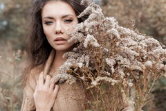 一件米黄毛线衣的美丽的哀伤的逗人喜爱的可爱的妇女宽在干草在秋天冷的阴暗天,灰棕色照片的领域 图库摄影 一件米黄毛线衣的美丽的哀伤的逗人喜爱的可爱的妇女宽在干草在秋天冷的阴暗天,灰棕色照片的领域 图库摄影