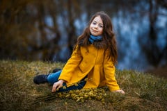 一件黄色外套的一个女孩在森林里在早期的春天有枝杈杨柳分支的 女孩furing的涨水或水位高 免版税库存图片 一件黄色外套的一个女孩在森林里在早期的春天有枝杈杨柳分支的 女孩furing的涨水或水位高 免版税库存图片