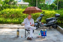三亚,海南,中国- 5月16日:2019年:在一热的天,在街道的不熟悉的中国人坐在伞和睡眠下 库存图片 三亚,海南,中国- 5月16日:2019年:在一热的天,在街道的不熟悉的中国人坐在伞和睡眠下 库存图片