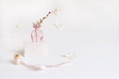 与一张手工纸丝绸丝带贺卡、短管轴和樱花的女性春天文具大模型场面 免版税库存照片 与一张手工纸丝绸丝带贺卡、短管轴和樱花的女性春天文具大模型场面 免版税库存照片