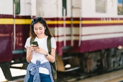 亚裔女性旅客、美丽的妇女使用地图的或社会媒介在智能手机登记在火车站铁路平台 免版税库存照片 亚裔女性旅客、美丽的妇女使用地图的或社会媒介在智能手机登记在火车站铁路平台 免版税库存照片