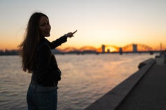 享受沿河道加瓦河的年轻女人日落步行有在清楚的天空蔚蓝的一个看法 免版税库存图片 享受沿河道加瓦河的年轻女人日落步行有在清楚的天空蔚蓝的一个看法 免版税库存图片