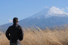 人旅客身分和看与雪加盖的和天空蔚蓝的美丽的富士山湖kawaguchiko,日本 免版税图库摄影 人旅客身分和看与雪加盖的和天空蔚蓝的美丽的富士山湖kawaguchiko,日本 免版税图库摄影
