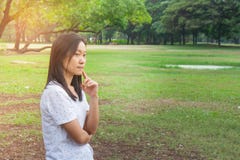 假期和假日概念:妇女佩带的白色T恤杉 站立在绿草的她在公园 库存照片 假期和假日概念:妇女佩带的白色T恤杉 站立在绿草的她在公园 库存照片