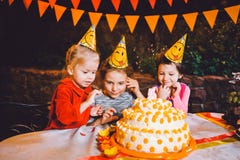 儿童` s生日聚会 在桌上吃蛋糕用他们的手和抹上他们的面孔的三个快乐的儿童女孩 乐趣a 图库摄影 儿童` s生日聚会 在桌上吃蛋糕用他们的手和抹上他们的面孔的三个快乐的儿童女孩 乐趣a 图库摄影