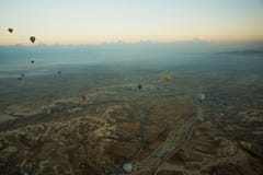 卡帕多细亚,土耳其:清早顶视图从气球、有薄雾的风景与雾与山和五颜六色的气球 免版税库存图片 卡帕多细亚,土耳其:清早顶视图从气球、有薄雾的风景与雾与山和五颜六色的气球 免版税库存图片