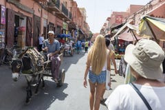 参观Djemaa el Fna -马拉喀什的麦地那处所的市场的游人2014年8月的24日在马拉喀什,摩洛哥 图库摄影 参观Djemaa el Fna -马拉喀什的麦地那处所的市场的游人2014年8月的24日在马拉喀什,摩洛哥 图库摄影