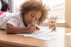在图画的小的小孩女孩放下集中 混合非洲女孩学会和使用在幼儿园类 孩子享用 免版税库存照片 在图画的小的小孩女孩放下集中 混合非洲女孩学会和使用在幼儿园类 孩子享用 免版税库存照片