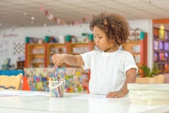 在图画的小的小孩女孩集中 混合非洲女孩学会和使用在幼儿园类 孩子享受手文字 图库摄影 在图画的小的小孩女孩集中 混合非洲女孩学会和使用在幼儿园类 孩子享受手文字 图库摄影
