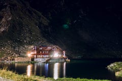 在山湖的岸的房子的夜视图、旅馆,Balea紫胶、旅游业和假期概念、旅行和活跃生活方式, 免版税库存照片 在山湖的岸的房子的夜视图、旅馆,Balea紫胶、旅游业和假期概念、旅行和活跃生活方式, 免版税库存照片