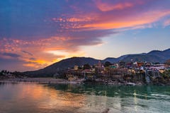 在瑞诗凯诗、圣洁镇和旅行目的地的黄昏时间在印度 五颜六色的反射在恒河的天空和云彩 免版税库存照片 在瑞诗凯诗、圣洁镇和旅行目的地的黄昏时间在印度 五颜六色的反射在恒河的天空和云彩 免版税库存照片