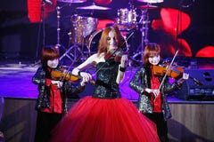 在阶段,传神红发小提琴手玛丽亚Bessonova儿子孪生 小提琴三重奏两几代红色火热的音乐家 免版税图库摄影 在阶段,传神红发小提琴手玛丽亚Bessonova儿子孪生 小提琴三重奏两几代红色火热的音乐家 免版税图库摄影