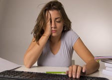 坐在看起来疲乏用尽和不耐烦的重音的计算机书桌的年轻可爱的学生女孩或职业妇女 库存照片 坐在看起来疲乏用尽和不耐烦的重音的计算机书桌的年轻可爱的学生女孩或职业妇女 库存照片