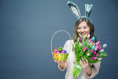 少妇在家复活节在拿着在郁金香棍子和buquet的兔宝宝耳朵的celbration概念装饰鸡蛋 库存照片 少妇在家复活节在拿着在郁金香棍子和buquet的兔宝宝耳朵的celbration概念装饰鸡蛋 库存照片