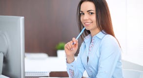 年轻深色的女商人看起来工作在办公室的学生女孩 西班牙或拉丁美洲的女孩愉快在工作 免版税库存图片 年轻深色的女商人看起来工作在办公室的学生女孩 西班牙或拉丁美洲的女孩愉快在工作 免版税库存图片