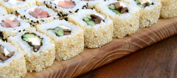 很多寿司卷特写镜头用不同的装填的说谎木表面上 煮熟的经典日本食物宏观射击与 图库摄影 很多寿司卷特写镜头用不同的装填的说谎木表面上 煮熟的经典日本食物宏观射击与 图库摄影