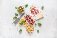 意大利或地中海食物烹调和成份在白色具体桌上 Tagliatelle pene面团橄榄橄榄油蕃茄 免版税图库摄影 意大利或地中海食物烹调和成份在白色具体桌上 Tagliatelle pene面团橄榄橄榄油蕃茄 免版税图库摄影