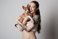 拥抱和亲吻她小的小狗basenji狗的一逗人喜爱的被刺字的年轻女人的画象 在狗和所有者之间的爱 库存照片 拥抱和亲吻她小的小狗basenji狗的一逗人喜爱的被刺字的年轻女人的画象 在狗和所有者之间的爱 库存照片