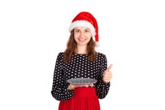 拿着一块空的板材和显示赞许的可爱的女孩在她的手上,当为新年假日做准备时 情感gir 免版税图库摄影 拿着一块空的板材和显示赞许的可爱的女孩在她的手上,当为新年假日做准备时 情感gir 免版税图库摄影