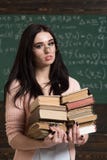 拿着书的堆美丽的深色的女孩在她的手上 聪明的学生为检查做准备 库存照片 拿着书的堆美丽的深色的女孩在她的手上 聪明的学生为检查做准备 库存照片