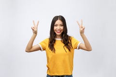 显示两个手指或胜利姿态与空白的copyspace区域的愉快的年轻亚裔妇女文本的,画象美丽 库存照片 显示两个手指或胜利姿态与空白的copyspace区域的愉快的年轻亚裔妇女文本的,画象美丽 库存照片