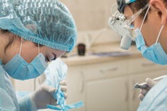 有一个患者和助理的牙医在牙齿干预时 牙医概念 口腔外科 操作过程 库存图片 有一个患者和助理的牙医在牙齿干预时 牙医概念 口腔外科 操作过程 库存图片