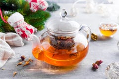 有花的玻璃茶壶栓了茶、热的茶在玻璃茶壶和蜂蜜用金属蜂蜜棍子在石背景 库存照片 有花的玻璃茶壶栓了茶、热的茶在玻璃茶壶和蜂蜜用金属蜂蜜棍子在石背景 库存照片