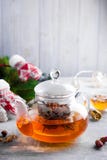 有花的玻璃茶壶栓了茶、热的茶在玻璃茶壶和蜂蜜用金属蜂蜜棍子在石背景 库存图片 有花的玻璃茶壶栓了茶、热的茶在玻璃茶壶和蜂蜜用金属蜂蜜棍子在石背景 库存图片