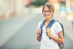 有袋子的,背包女小学生 现代愉快的青少年的学校女孩画象有袋子背包的 戴牙齿括号和眼镜的女孩 库存照片 有袋子的,背包女小学生 现代愉快的青少年的学校女孩画象有袋子背包的 戴牙齿括号和眼镜的女孩 库存照片
