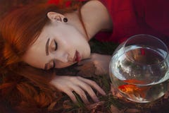 有长的红色头发的一美女在光在一个金鱼旁边的睡眠在水族馆 年轻红发妇女 图库摄影 有长的红色头发的一美女在光在一个金鱼旁边的睡眠在水族馆 年轻红发妇女 图库摄影